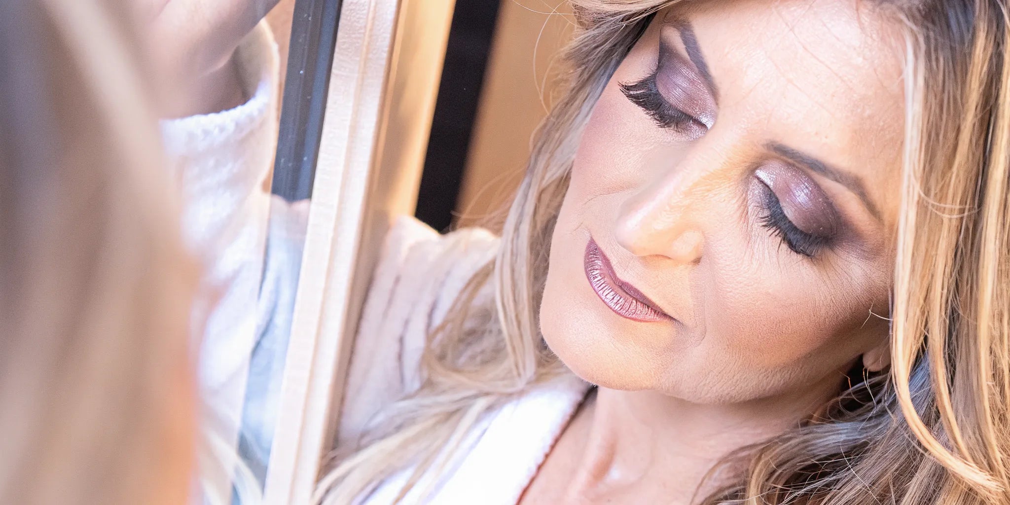 Elegant mature woman with soft, natural nude makeup look featuring luminous skin and neutral lips