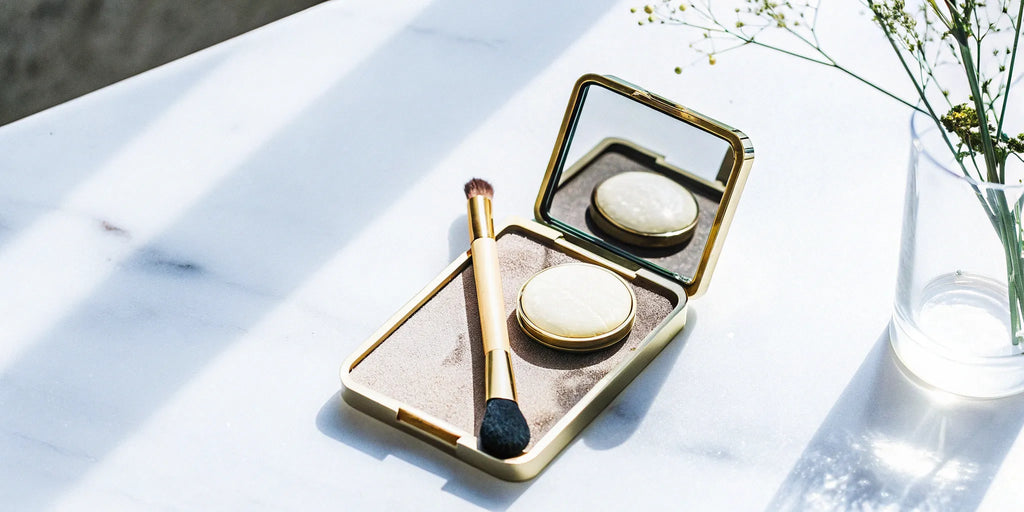 Best cream eyeshadow palette for mature eyes over 60 with a brush on a marble surface.