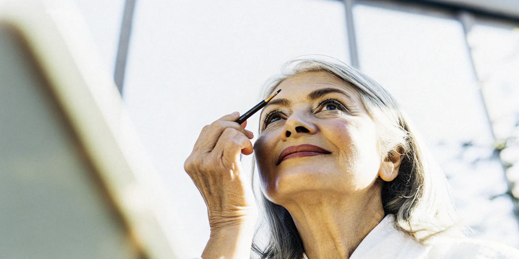 Woman over 60 applying a smooth, neutral matte eyeshadow.