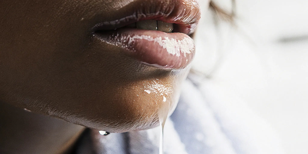 A woman's lips wearing a shiny, non-sticky clear lip gloss.
