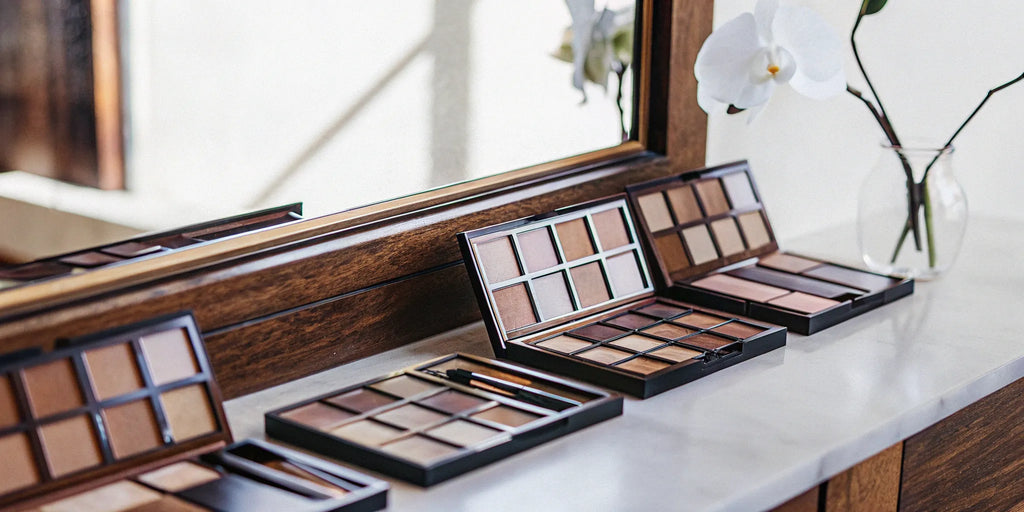 Holiday makeup gift sets in neutral shades displayed on a vanity.