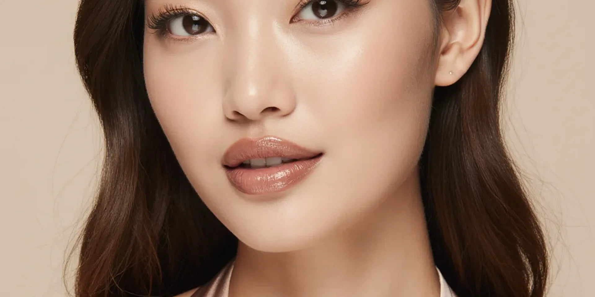 Woman with long soft waves wearing a rosy natural cream blush flush, olive-friendly shade