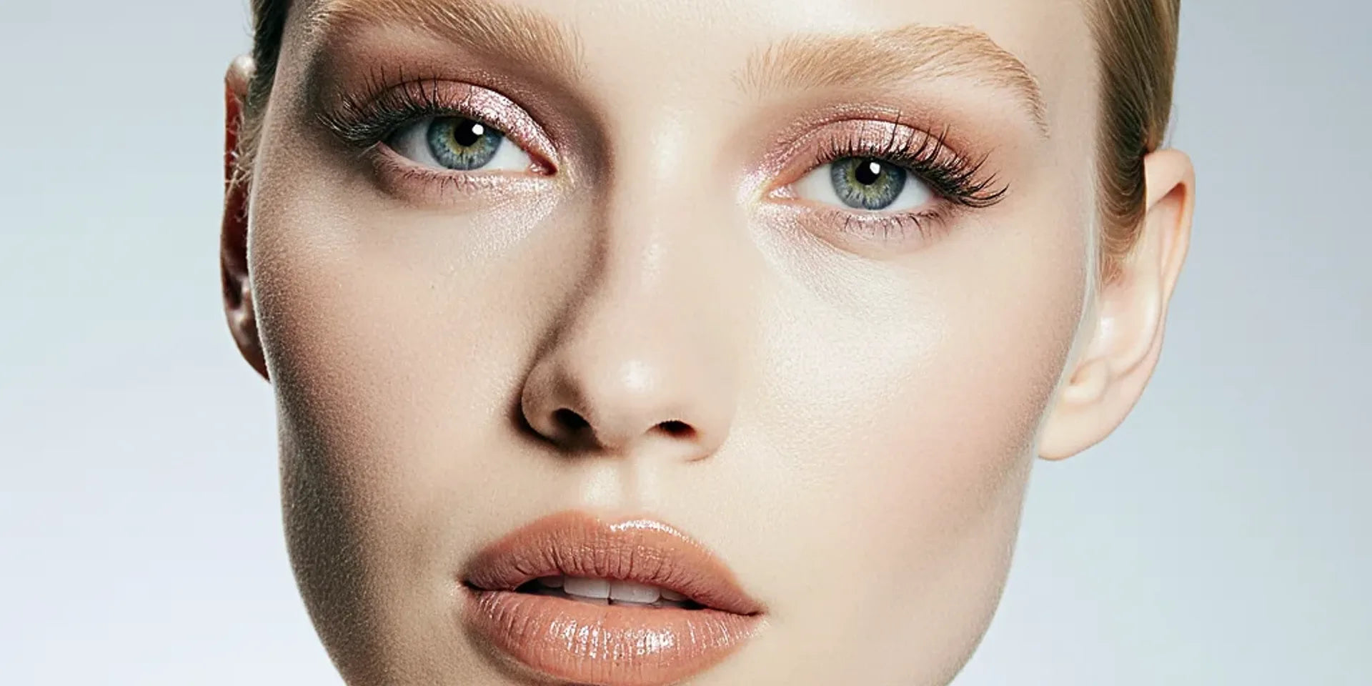 Close-up portrait of a woman with icy green eyes wearing soft nude eyeshadow