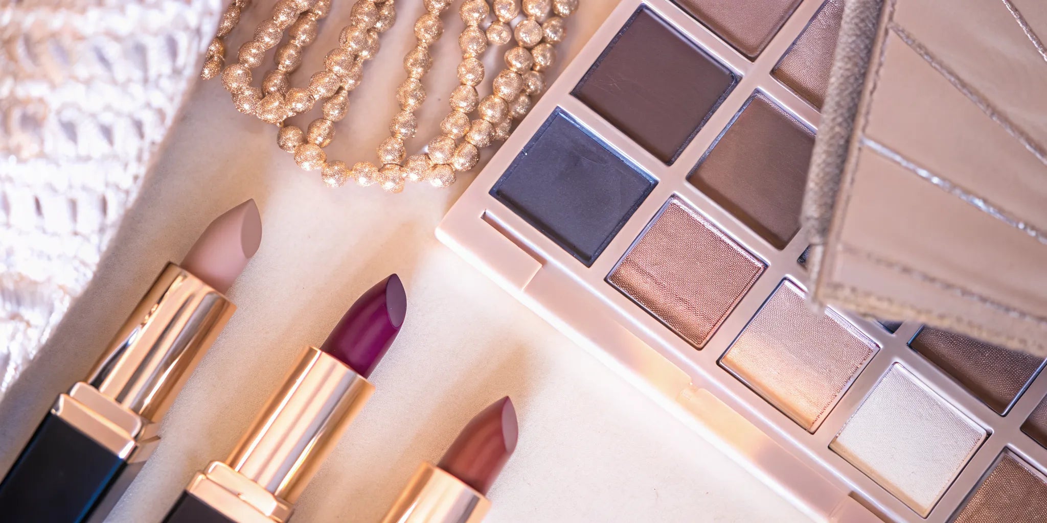 A luxurious flat-lay of nude lipstick shades with olive-toned skin swatches showing complementary nude and berry lip colors