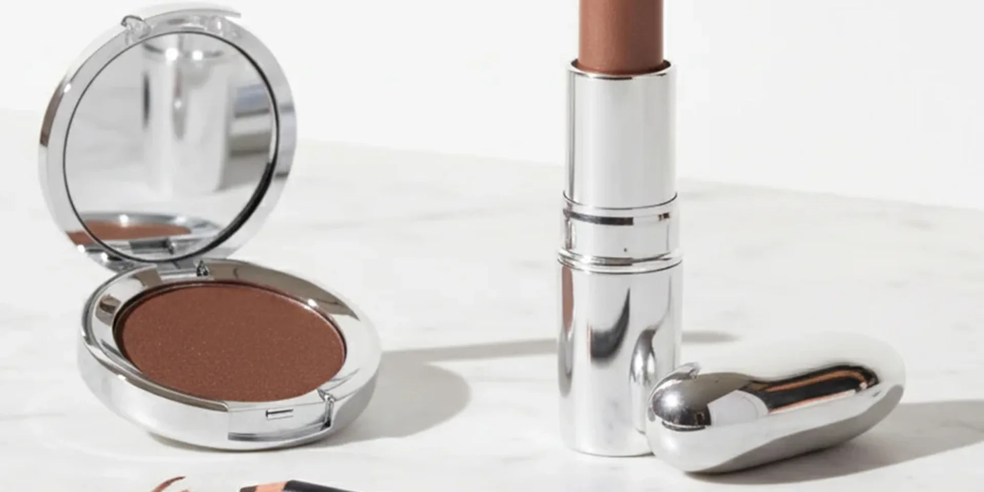 Coordinated nude and pink makeup shades arranged for a travel beauty capsule